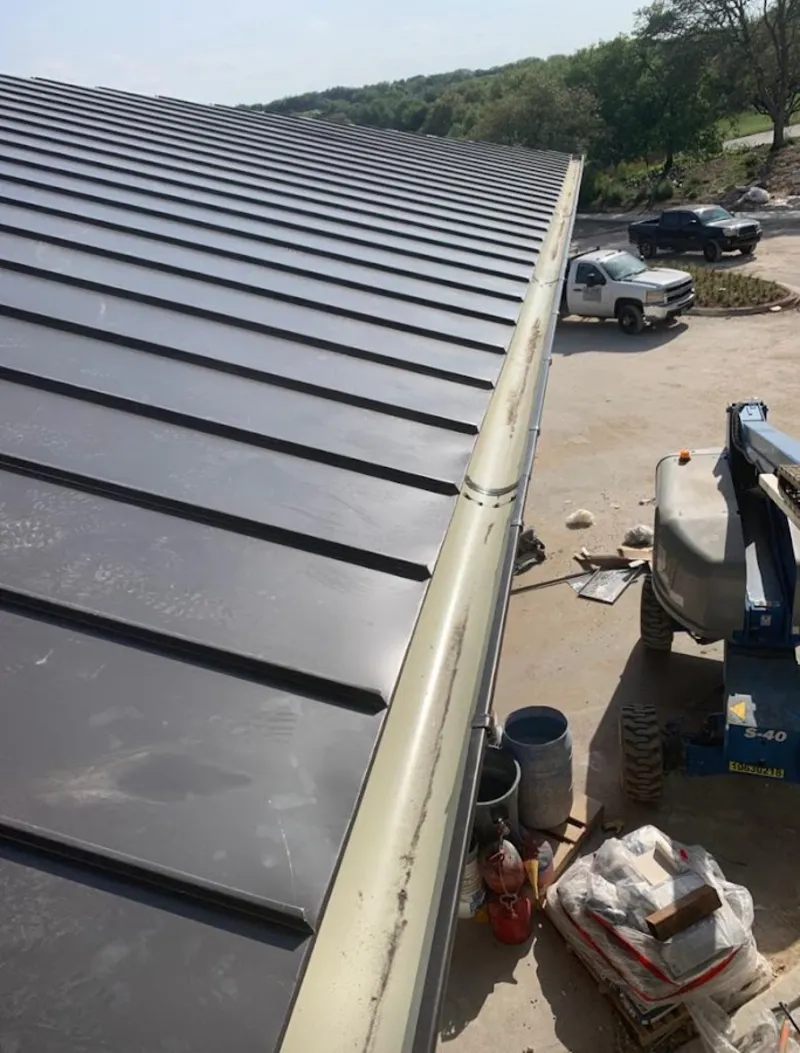 Standing seam panel and gutter detail on a metal roofing jobsite in Hayward